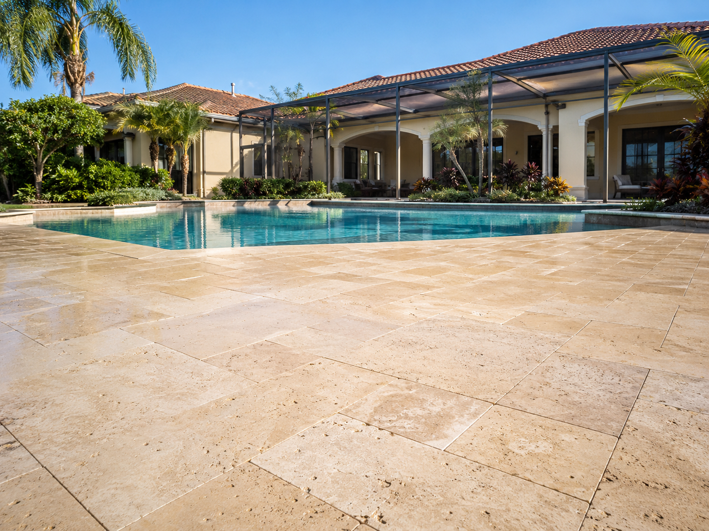 Clean travertine pool deck and screened lanai at a South Florida home after Coastal Pro cleaning